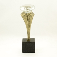 statuetka odlana z materiałów syntetycznych; wykończenie w kolorze patynowanego mosiądzu; szklany 'diament'; wysokość 25 cm