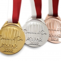 medal tłoczony z mosiądzu; wykończenie przez złocenie, srebrzenie i złocenie do koloru brązu; odlewane, szerokie ucho; tasiemka przeszywana; średnica 70mm; medal wykonany dla polskiej edycji konkursu Bocuse d'Or 2019