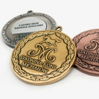 medale tłoczone z mosiądzu; wykończenie w trzech kolorach sportowych; wkładka personalizująca na rewersie medalu