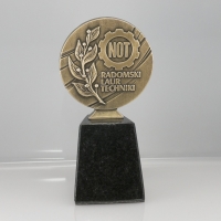 statuetka w formie medalu; odlew metalowy wykończony w kolorze mosiądzu patynowanego; podstawa czarny granit