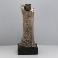 statuetka wykonana w technologii mieszanej; korpus odlany z materiałów syntetycznych; herb odlany z metalu; wykończenie w kolorze mosiądzu patynowanego; podstawa czarny granit