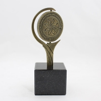 statuetka wykonana w formie medalu; odlew metalowy wykończony w kolorze mosiądzu patynowanego; podstawa czarny granit