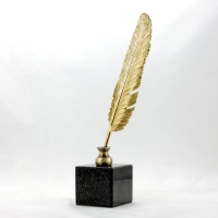 statuetka odlana z metalu; pióro złocone; podstawa czarny granit; wysokość ok. 32 cm